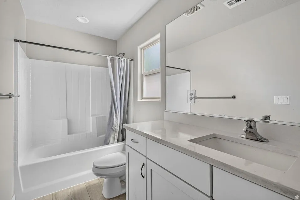 White vanity with a light-colored countertop, integrated sink, and chrome faucet