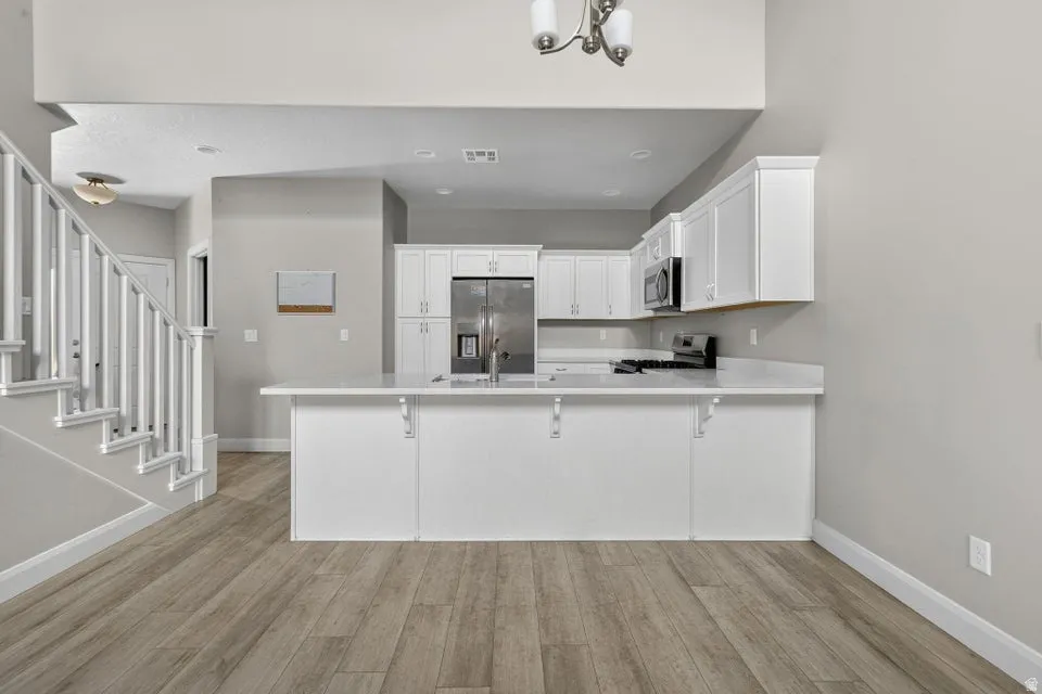 Open-concept kitchen with white cabinetry and light-toned countertops