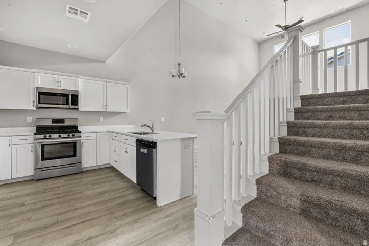 Kitchen with white cabinetry, stainless steel appliances, and a central island