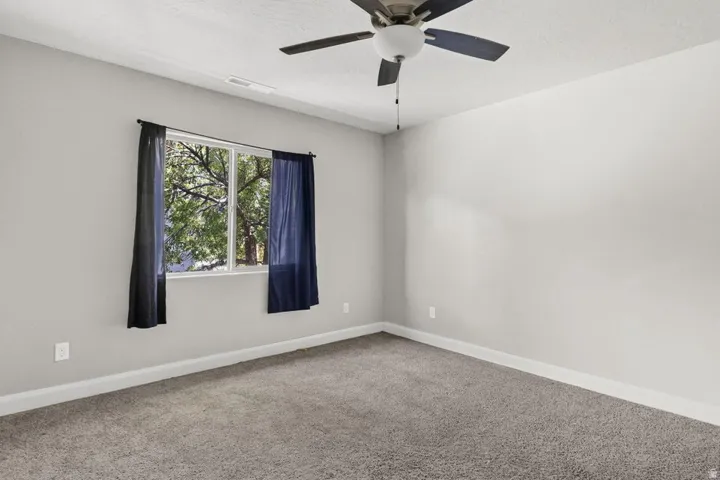 Neutral-toned walls, gray carpeting, and a white window frame