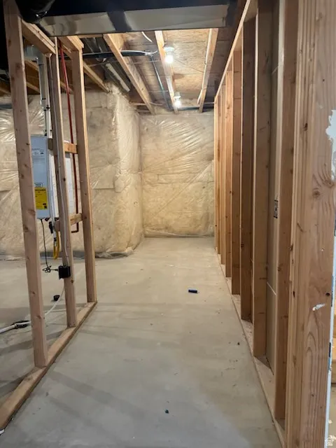 Unfinished space featuring wood framing, concrete flooring, and exposed ceiling joists