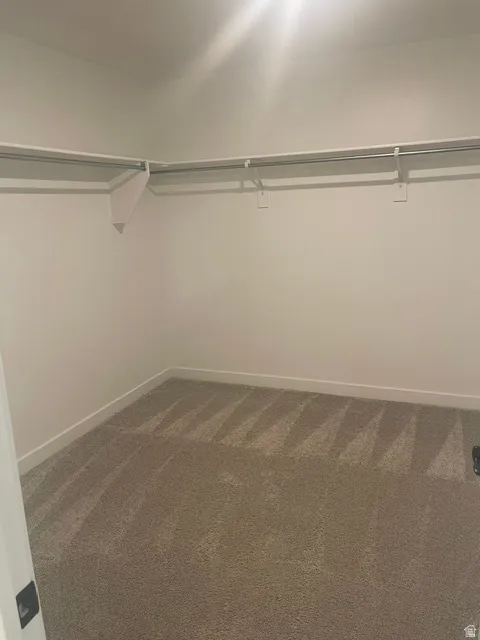 Neutral-toned carpet flooring with white baseboards and walls