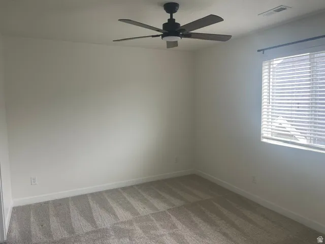 Neutral wall palette, wall-to-wall carpeting, window with blinds, and a ceiling fan with integrated lighting