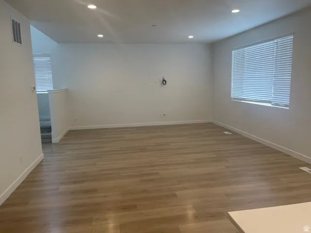 Spacious interior featuring wood-finish flooring, recessed lighting, and ample natural light through a large window