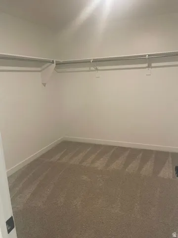 Neutral-toned carpet flooring with white baseboards and walls