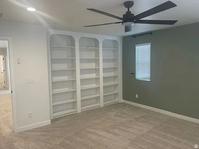 Built-in shelving, ceiling fan, carpet flooring, recessed lighting