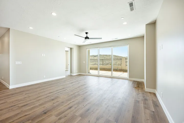 Spacious interior featuring wood-finish flooring, recessed lighting, and a ceiling fan