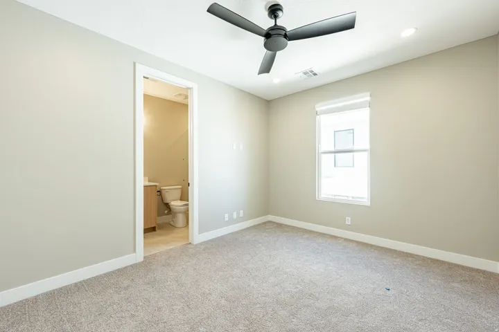 Carpeted room with a ceiling fan, recessed lighting, and a single window