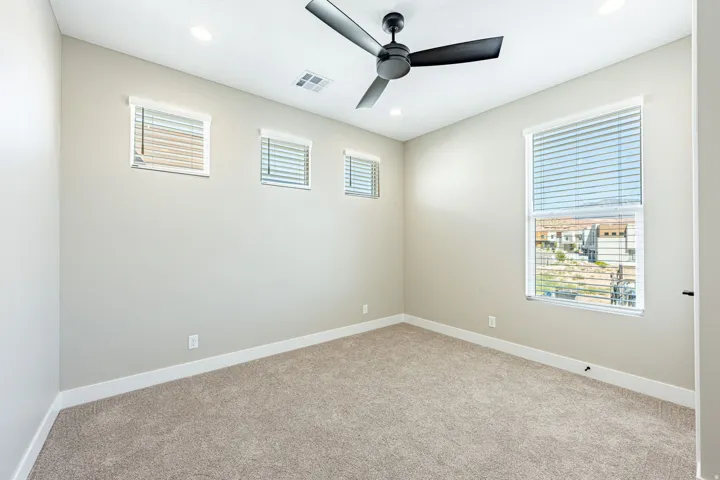 Recessed lighting, ceiling fan, neutral carpet, multiple windows, and light-toned walls