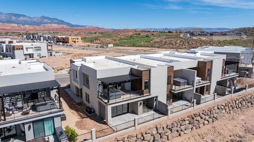 Modern multi-level architecture with private balconies, ground-level patios, and a contemporary exterior finish