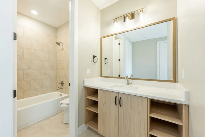 Vanity with stone-finish countertop, wood-finish cabinetry, and integrated sink
