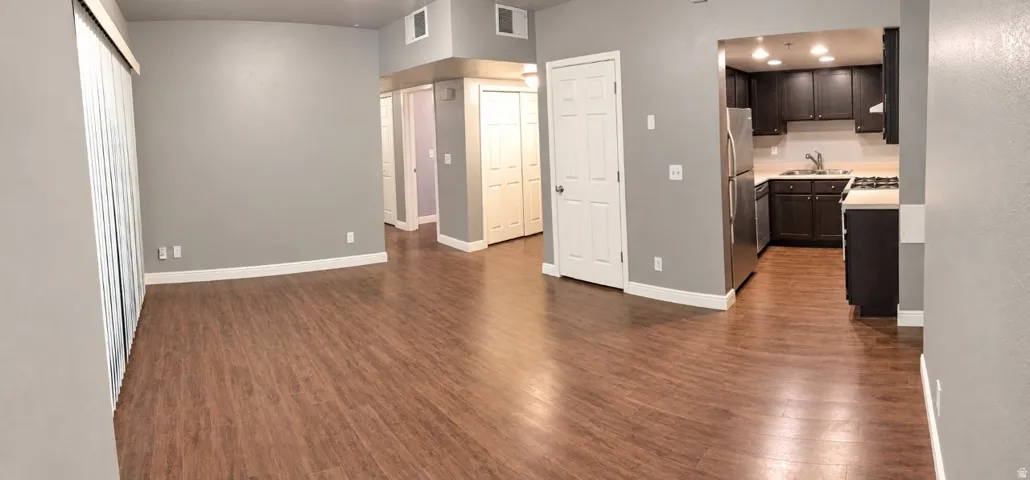 Spacious living area featuring wood-finish flooring, light gray walls, and white trim