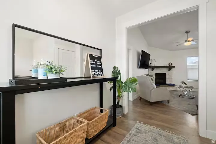 Wood-finish flooring throughout, a white wall paint finish, and a wide entryway