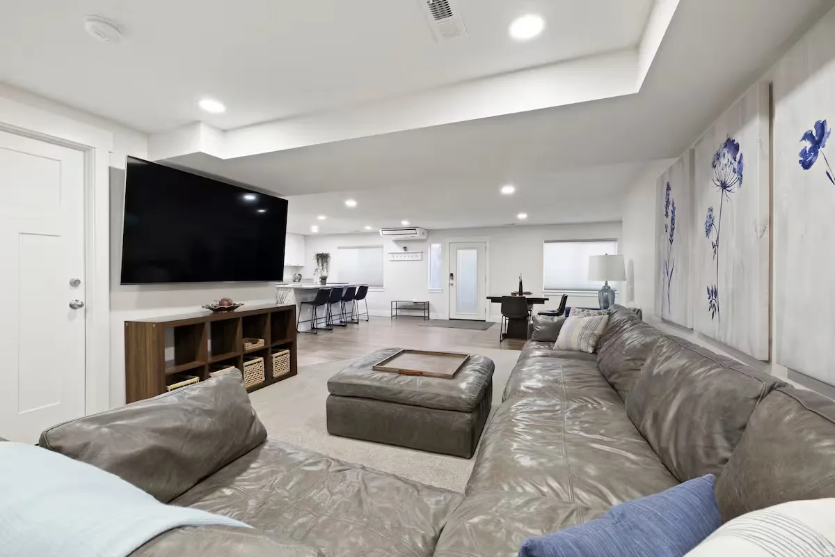Open-concept interior featuring recessed lighting, a built-in media console, a white paneled door, and durable flooring