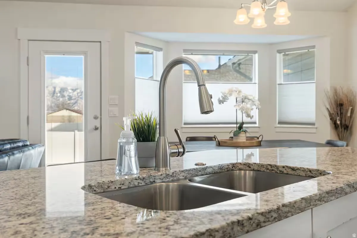 Granite-style countertop with double basin sink and gooseneck faucet