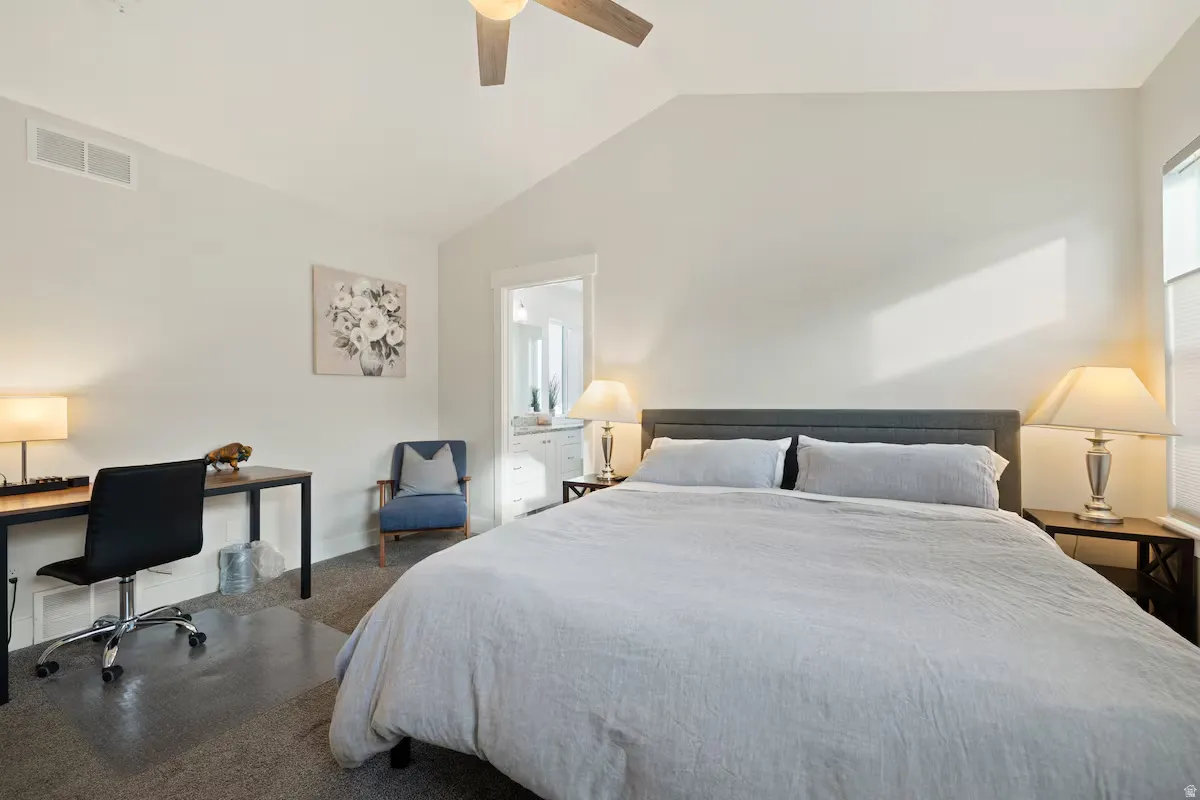 Vaulted ceiling with ceiling fan, wall-to-wall carpeting, window with blinds, and built-in task desk