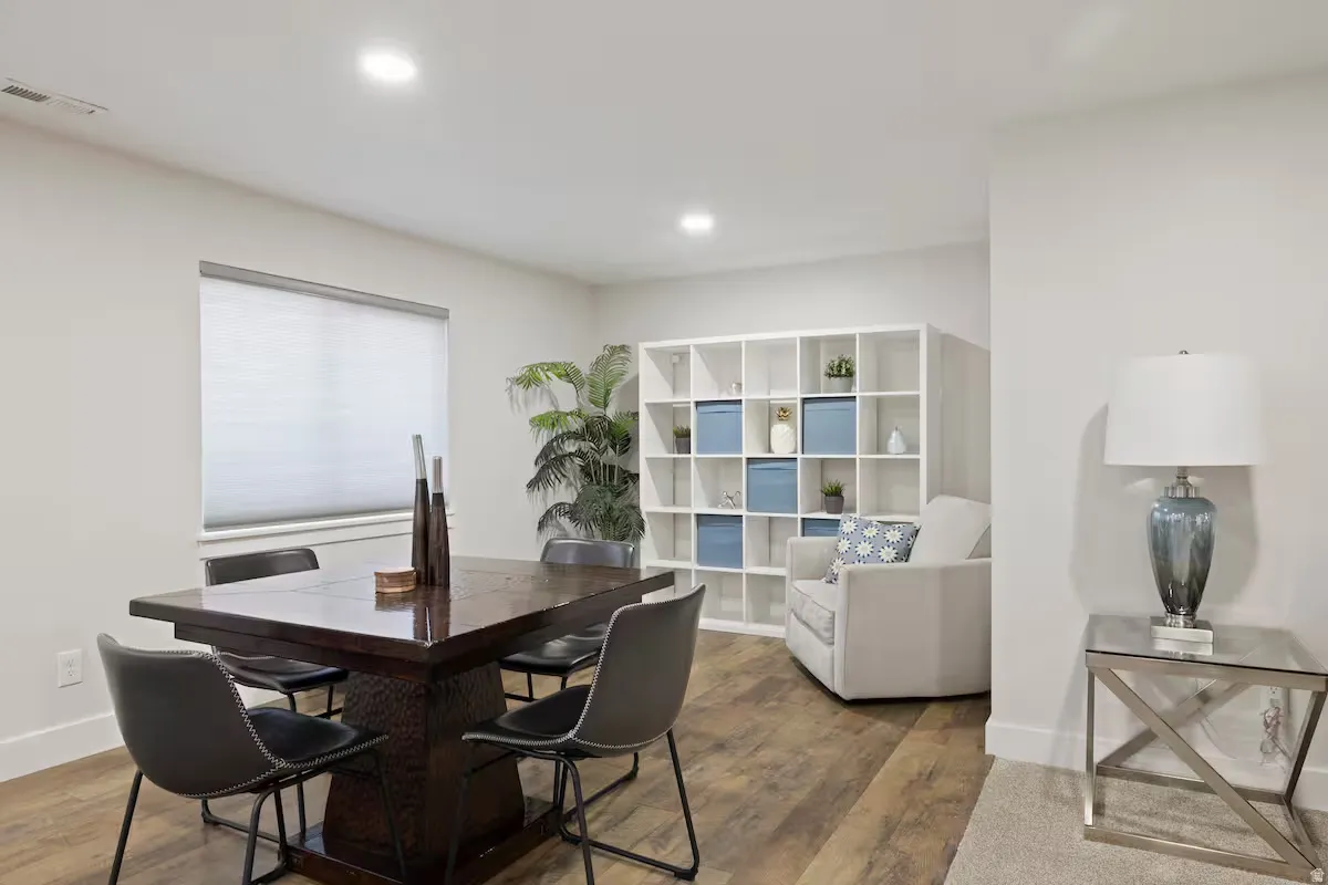 Recessed ceiling lighting, wood-finish flooring, a window with roller shade, and built-in shelving