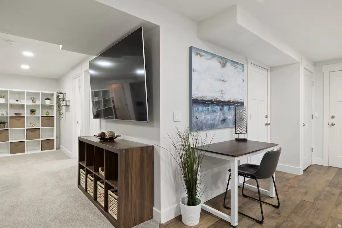 Recessed lighting, wood-finish flooring, and white interior doors