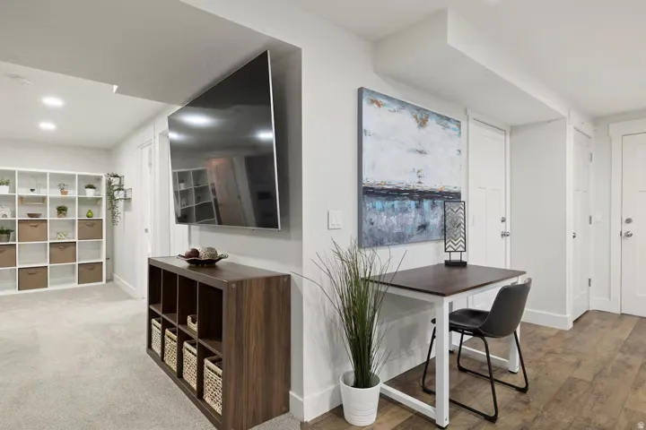 Recessed lighting, wood-finish flooring, and white interior doors