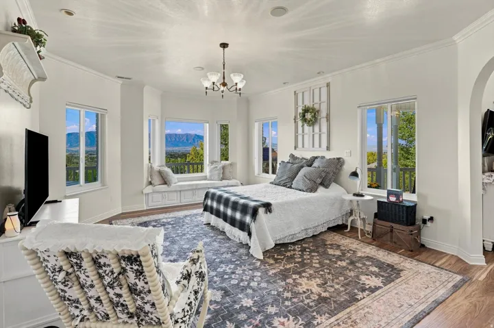 Bay window with integrated bench seating, wood-finish flooring, recessed lighting, crown molding, and a chandelier-style light fixture