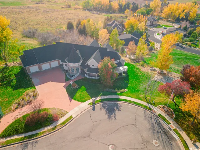 Brick paver driveway leading to a three-car garage