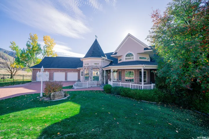 Stone and brick-accented exterior with a turret feature, covered porch, and multi-pane windows