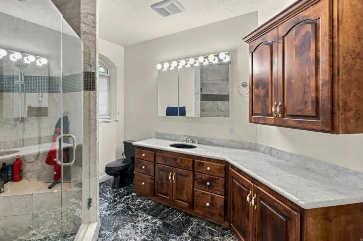 Spacious bathroom with a walk-in shower featuring a glass enclosure and built-in bench