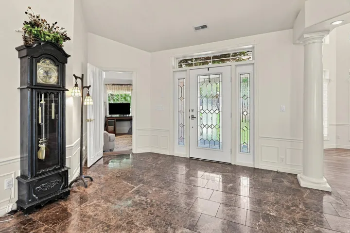 White double entry doors with decorative glass inserts, transom window, and sidelights