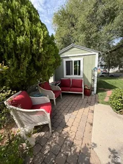 Paved patio area, dedicated outdoor structure, surrounding mature trees, and garden landscaping