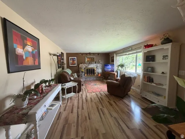 Wood-finish flooring throughout, stone-clad fireplace, built-in shelving, expansive windows, and a built-in console table