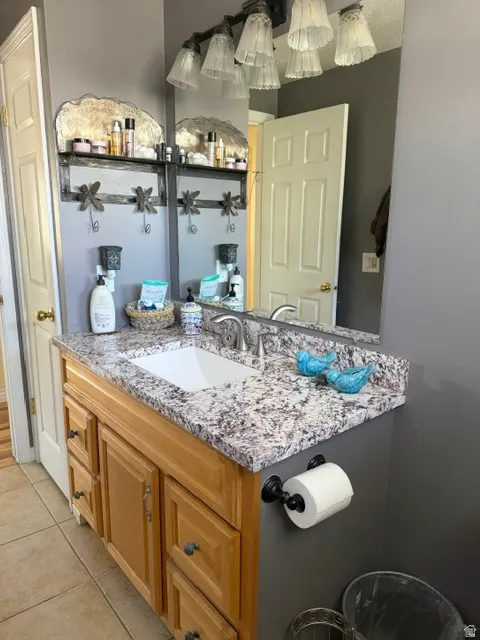 Vanity with a neutral-toned countertop, integrated rectangular sink, and wood-finish cabinetry