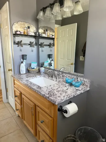 Vanity with a neutral-toned countertop, integrated rectangular sink, and wood-finish cabinetry