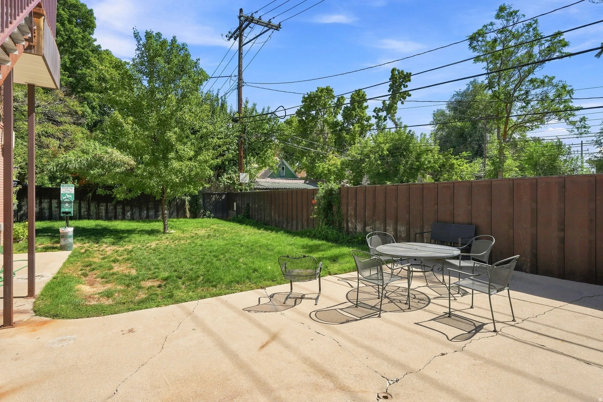 Expansive concrete patio with a privacy fence and grassy area