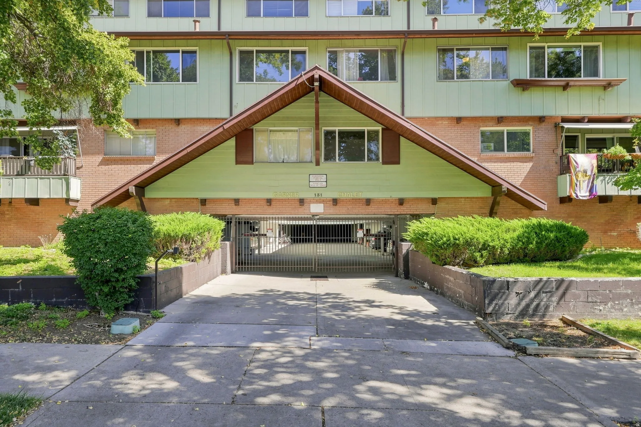 Multi-level facade with a peaked roof entrance, brick and siding exterior, and integrated ground-level parking access