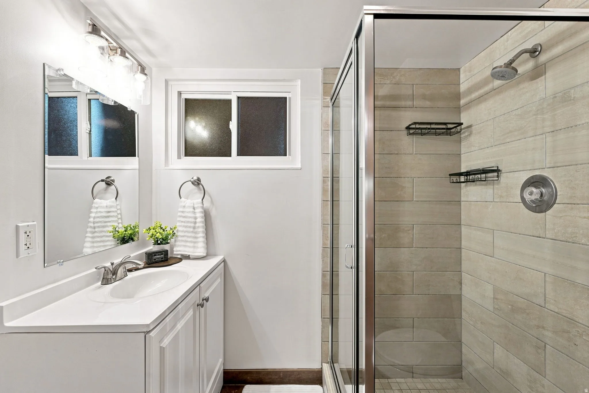 Vanity with white cabinetry and integrated sink, chrome faucet, and rectangular mirror