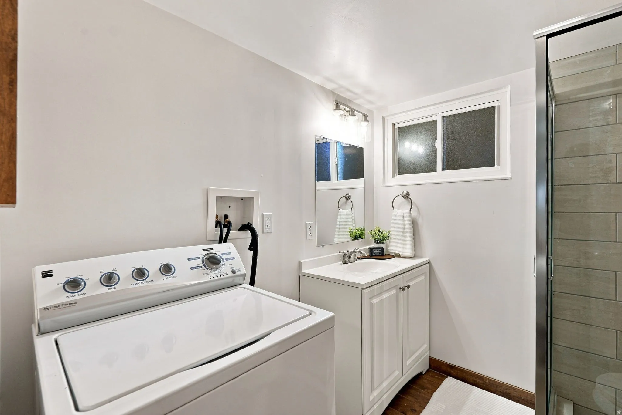 White vanity with integrated sink, chrome faucet, and mirrored medicine cabinet