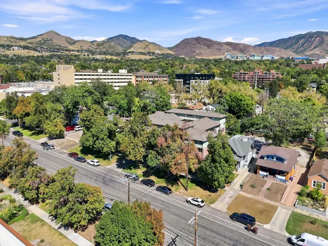 Residential area with mature trees, established roadways, and distant mountain backdrop