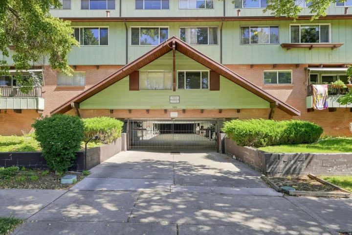Multi-level facade with a peaked roof entrance, brick and siding exterior, and integrated ground-level parking access