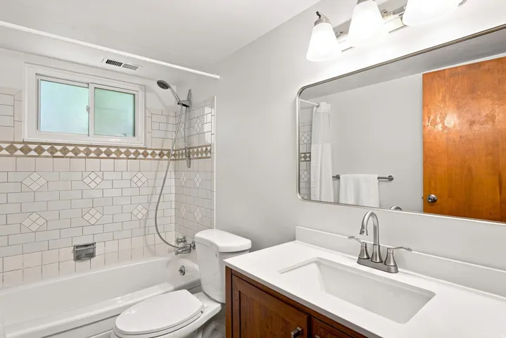 White subway tile shower surround with decorative accent band