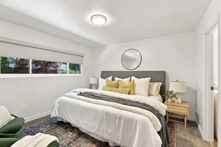 Flush-mount ceiling light fixture, white walls, and a window with roller shade
