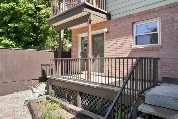 Lower-level patio with brick exterior and privacy fencing