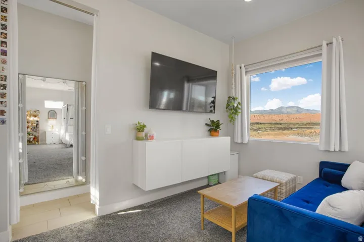 Expansive window with a mountain backdrop, wall-mounted floating cabinetry, and recessed lighting