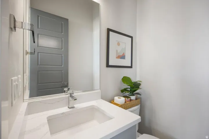 Vanity with a polished chrome faucet, rectangular undermount sink, and light-toned countertop