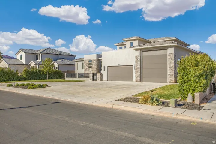 Contemporary-style residence with a stucco and stone veneer exterior, two-car garage, and an attached single-car garage