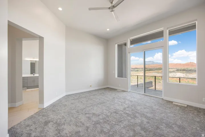 Spacious room with high ceilings, recessed lighting, and a modern ceiling fan