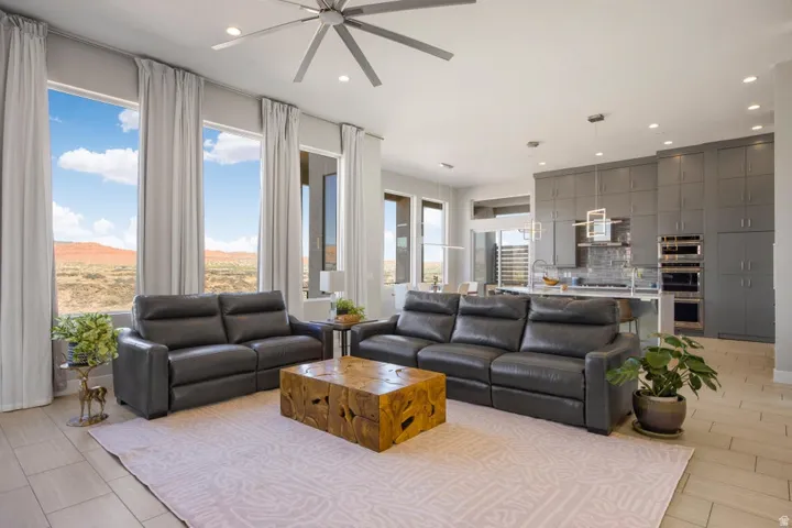 Open-concept living space featuring high ceilings, large format tile flooring, and multiple floor-to-ceiling windows