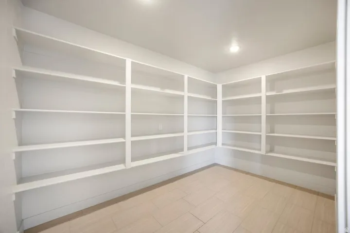 Expansive room featuring extensive built-in shelving, light-toned flooring, and recessed ceiling lighting