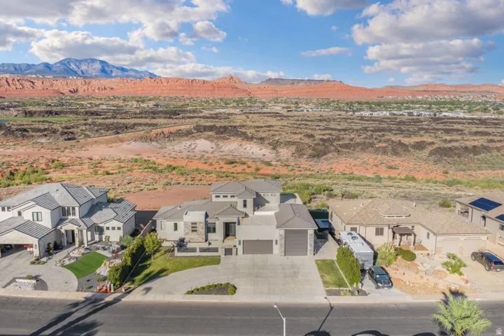 Modern architectural style, multi-level design, attached two-car garage, paved driveway, landscaped front yard