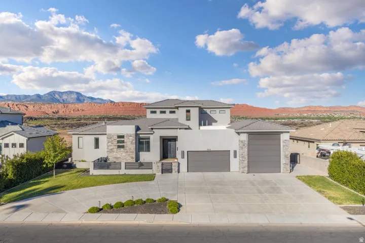 Contemporary exterior with stone accents, a multi-car driveway, and integrated garage doors
