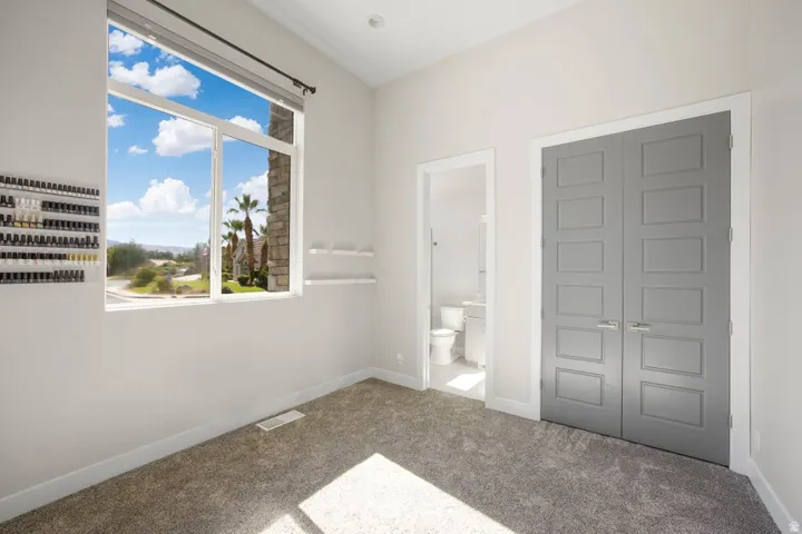 High ceilings featuring recessed lighting, a large window, gray paneled doors, and plush carpet flooring